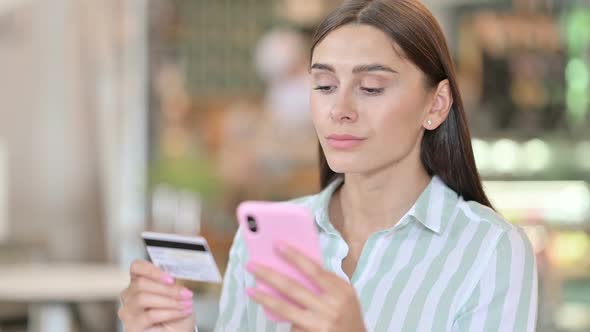 Portrait of Young Latin Woman with Successful Online Payment on Smartphone