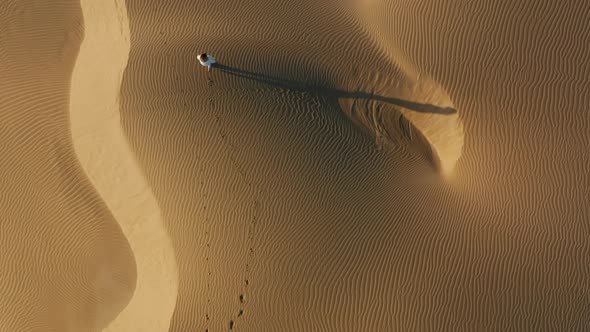  Aerial View of the Woman Walking By Sand Dunes in the Desert Nature