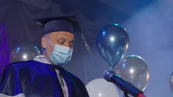 University Lecturers in Gown and Medical Mask are Solemnly Presenting Diplomas to Graduates Online