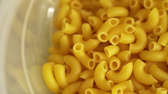 Panoramic shot. The macaroni rolls are lying in a container.