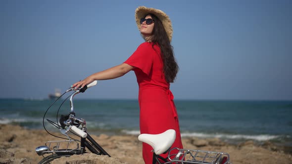 Happy Caucasian Woman with Bike Standing Outdoors in Sunshine Admiring Beauty of Mediterranean Sea