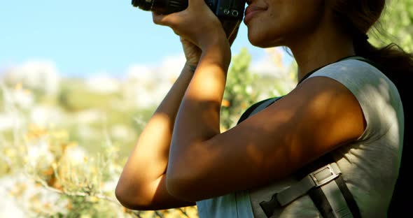 Female hiker clicking photos with digital camera