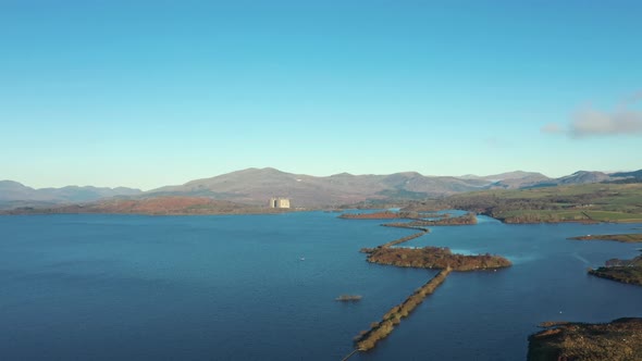 Aerial drone view over lake in Wales with a dismissed nuclear power plant on