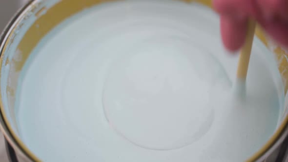 Closeup of a Painter Stirring White Paint