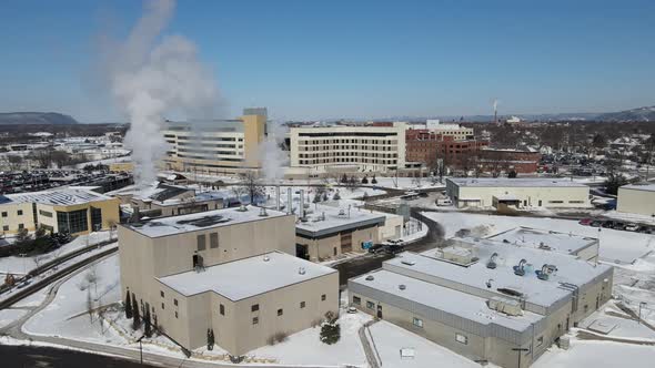 Panoramic view over large building complex in winter. Snow covered ground. Brilliant blue sky.