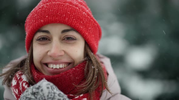 Slow Motion Portrait of Funny Smiling Woman in Knitted Hat and Scarf in Snowy Winter Park at Frozzy