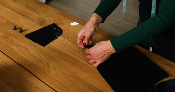 Step by step, 50-yers old woman sewing fabric with hand