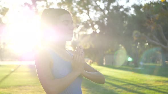 A beautiful young hispanic woman looking calm and relaxed in a prayer yoga pose during a meditation