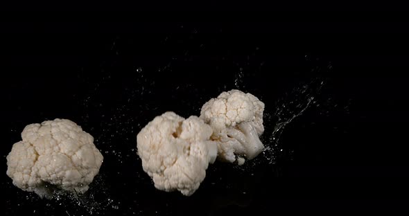 Cauliflower, brassica oleracea, Vegetable falling into Water against Black Background