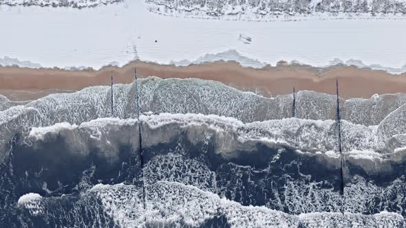 Man on snowy beach, Baltic sea in winter, aerial view