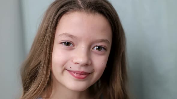 Beautiful little girl laughs at the camera close-up