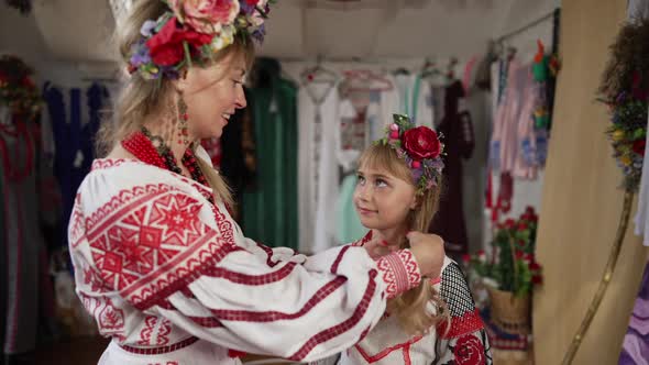 Smiling Ukrainian Woman Caressing Long Hair of Happy Girl in Traditional Embroidered Dress