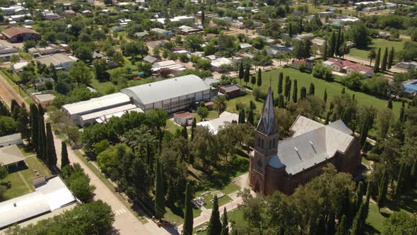 Orbital parallax of romantic style church surrounded by trees with Santa Anita little town in backgr