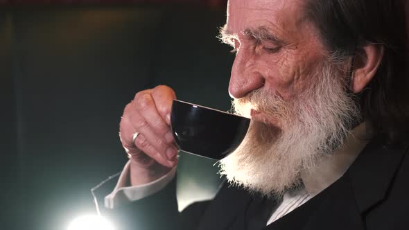 Bearded Mature Man Drinking Cup of Coffee Alone