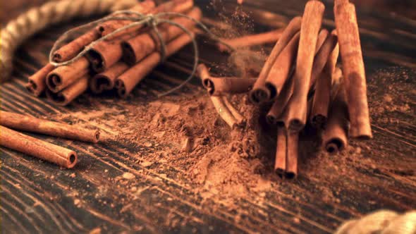 Super Slow Motion Cinnamon Sticks Fall on a Wooden Table