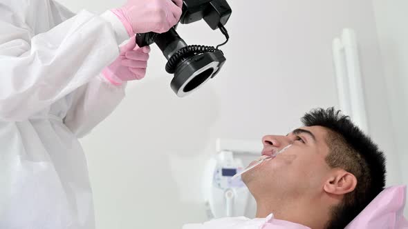 Dentist with Camera Making Shots of Beautiful Young Patient's Smile