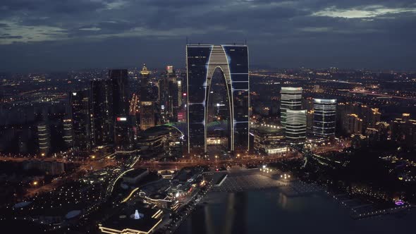 Aerial of CBD buildings by Jinji Lake at night in Suzhou, China.
