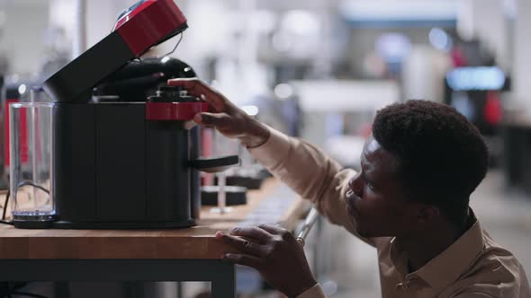 Man is Viewing Modern Coffee Machine in Home Appliance Store Young Black Guy is Shopping in Mall