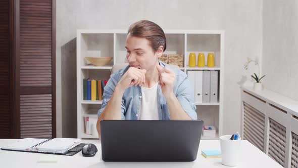 Workplace of freelance worker at home office. Young man works using computer.