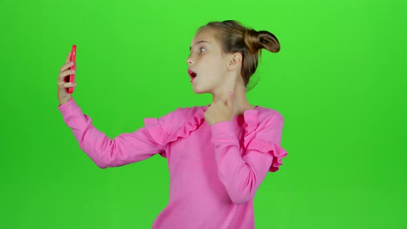 Baby Girl Makes Selfie on Her Phone. Green Screen. Slow Motion