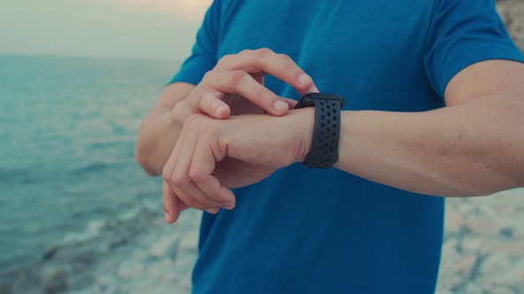 Handsome sportsmen using the smartwatch checking heart rate.