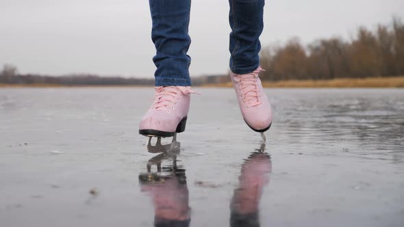 Young Woman Ice Skating on a Frozen Lake on a Freezing Winter Day. Legs of Skater on Winter Ice Rink