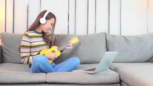 Young asian woman play ukulele