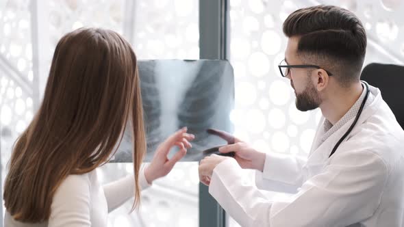 Man and Woman Look at Xray of Patient