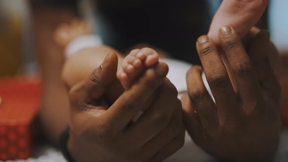 Black Father Playing with Baby Feet