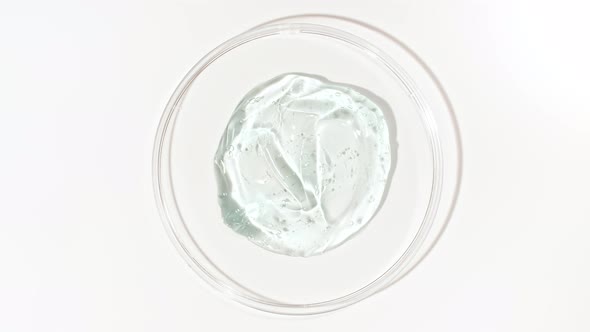 Rotation of Transparent Blue Cosmetic Gel Fluid with Bubbles in a Glass Bowl of Petri