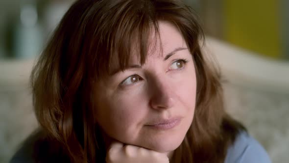 Portrait of Happy Woman Sitting on Sofa at Home and Dreaming Cinematic Shot / Videohive