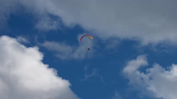 Parachute gliding against the blue sky