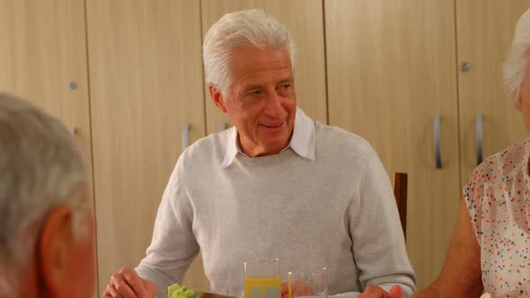 Happy senior man having meal with his friends