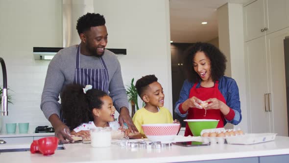 Happy african american family baking together in kitchen