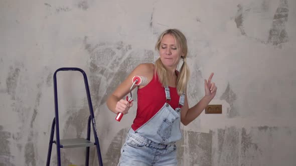 Happy Young Woman Cheerfully Dances Against the Background of Renovation in the House, Slow Motion