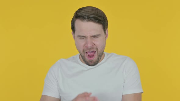 Tired Young Man Yawning on Yellow Background
