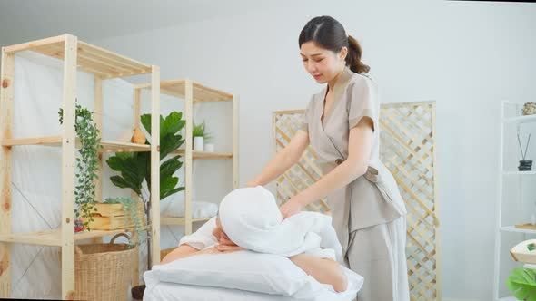 Asian young happy woman feeling relax during shoulder and back massage.