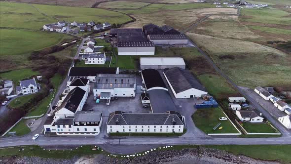 Aerial of a Distillery and Loch Indaal Shore in Islay Scotland