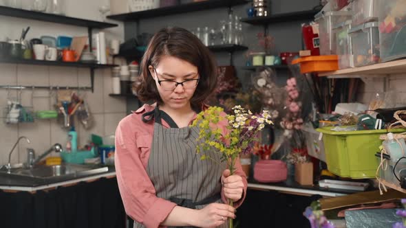 Female Making Bouquet From Summer Wild Flowers Close Up. Woman at Shop Workshop. Florist at Work