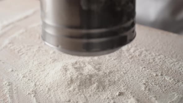 Camera follows sifting flour. Slow Motion.