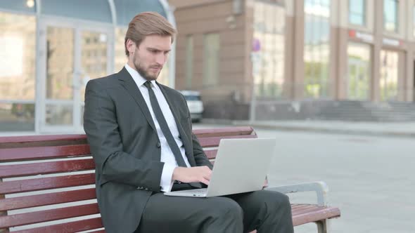Rejecting Businessman in Denial While Using Laptop Sitting Outdoor on Bench