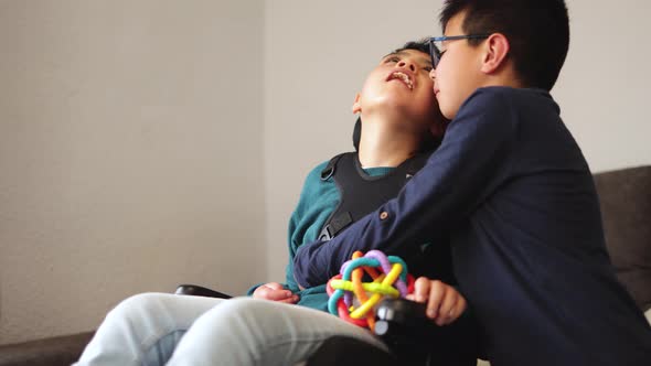 Child Having Tender Moment with His Brother with Disability in Wheelchair  Family Love Concept