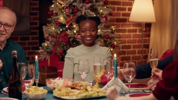 Young African American Woman Smiling Heartily at Camera While Enjoying Christmas Dinner