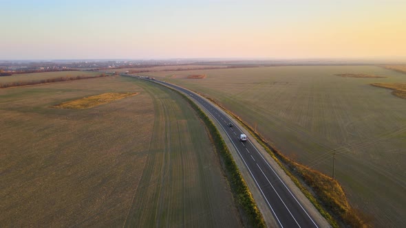 Aerial View of Intercity Road with Fast Driving Cars at Sunset