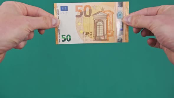 Male Hands Show a Banknote of 50 Euros From Top to Bottom on Green Screen