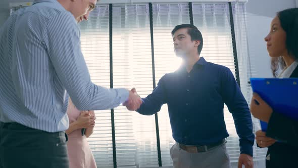 Group of young businessman and woman handshake each other in office.