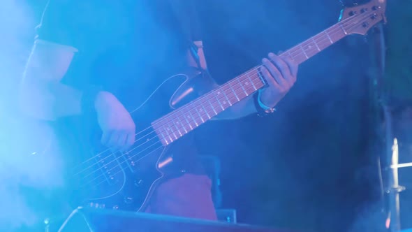 Bass Guitarist at a Rock Concert Plays Guitar on Open Stage. Slow Motion