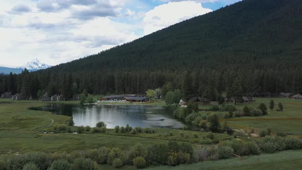 Aerial view of private resort next to a lake surrounded by beautiful natural landscape.