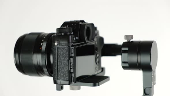 Gimbal with Digital Camera Rotates on White Background.