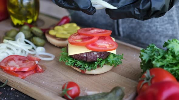 Making Burger  Putting Sliced Onion Circles on a Sandwich